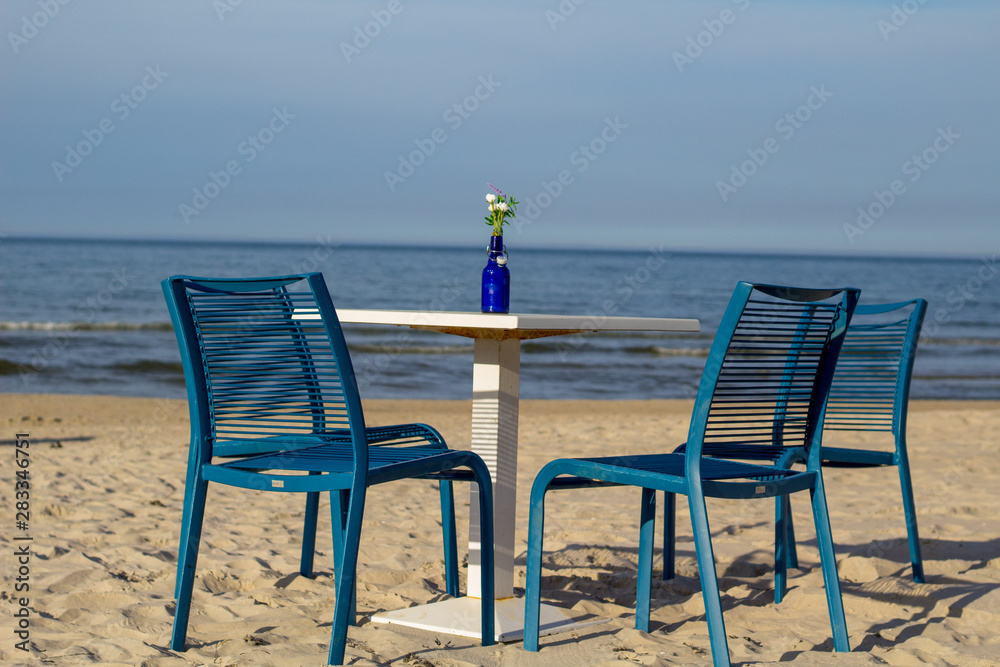 a table and 2 chairs at the beach