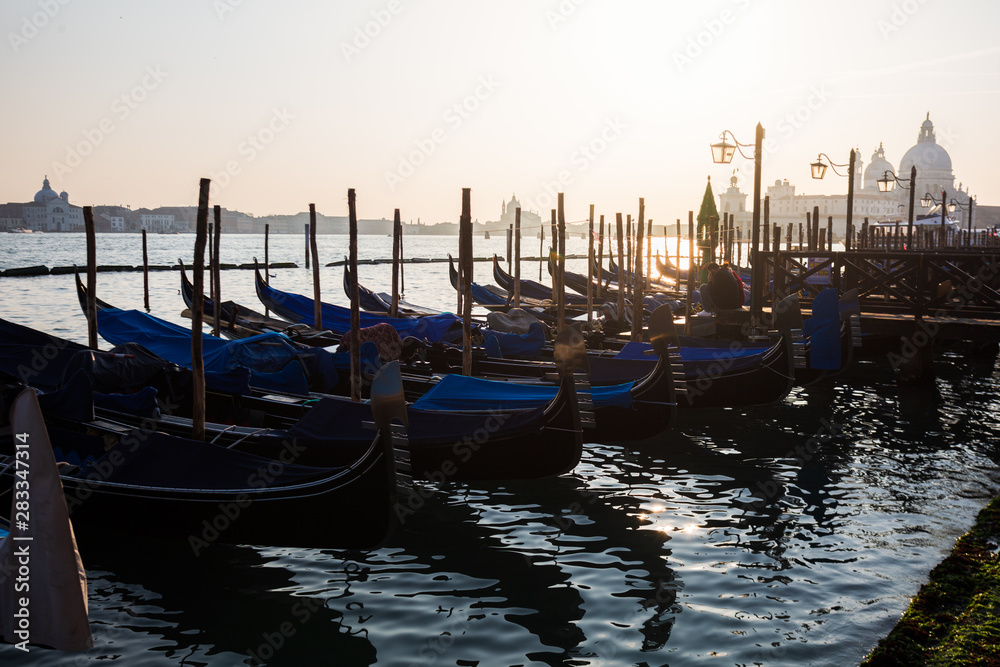 Traditional gondola and The Grand Canal and the Basilica di Santa Maria della Salute in Venice at sunset