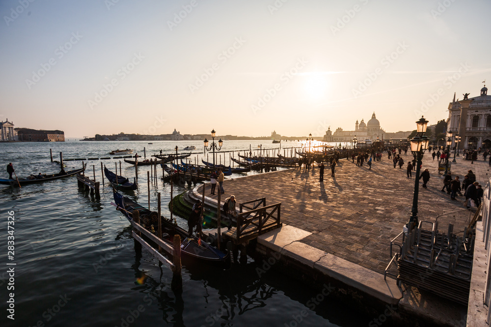 Fototapeta premium Traditional gondola and The Grand Canal and the Basilica di Santa Maria della Salute in Venice at sunset