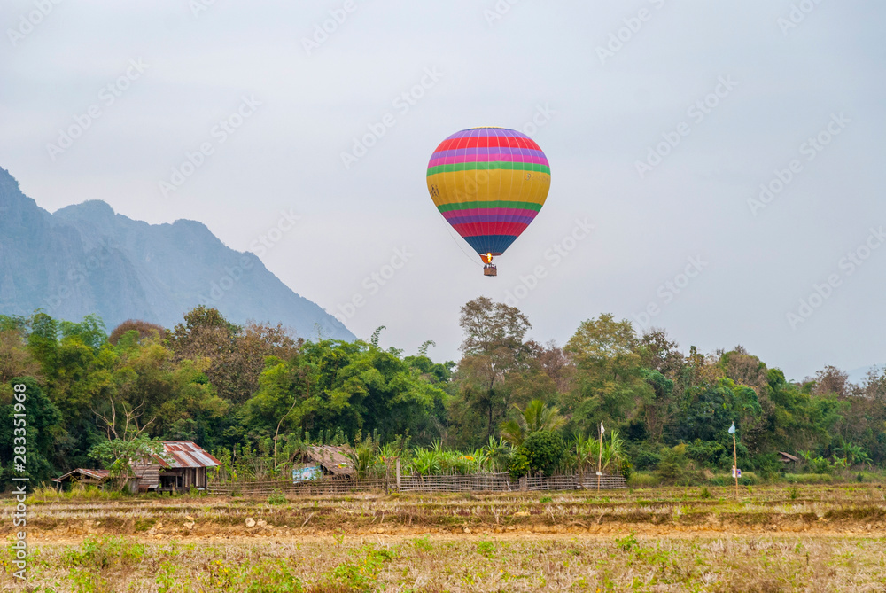 Naklejka premium Hot air balloon above hut