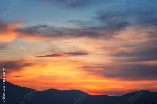Background of bright sky at sunset. Mountain silhouettes. photo