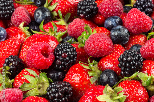 colorful tasty mix of wild forest berry fruits. Strawberry blueberry raspberry and blackberry. healthy eating nutrition vegan food concept background