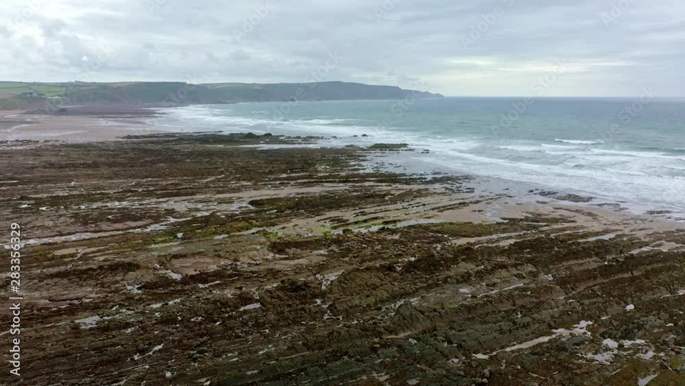 Aerial view of waves breaking on the rocky shoreline of Widemouth Bay in Cornwall UK, Aerial view of waves breaking on the rocky shoreline of Widemouth Bay in Cornwall UK,