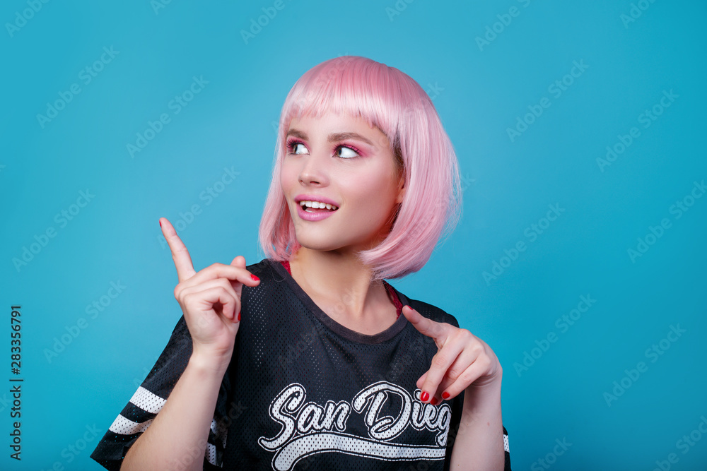 Obraz premium Pop girl portrait wearing pink wig looking showing the way