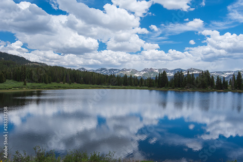 Fototapeta Naklejka Na Ścianę i Meble -  Landscape of clouds reflected in Little Molas Lake in Colorado with trees and mountains in the background