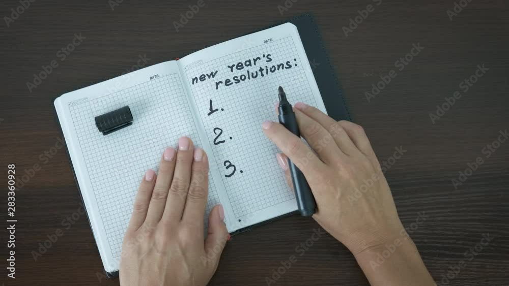 New year's resolutions. The woman writes down her goals in a notebook.