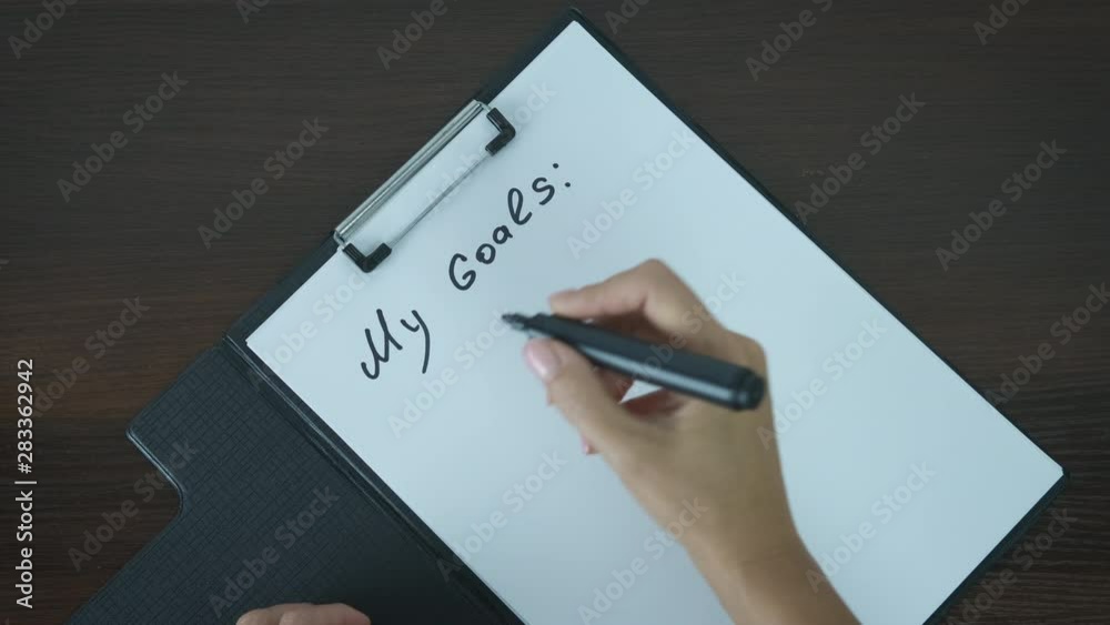 My Goals. Women's hands write down their goals.
