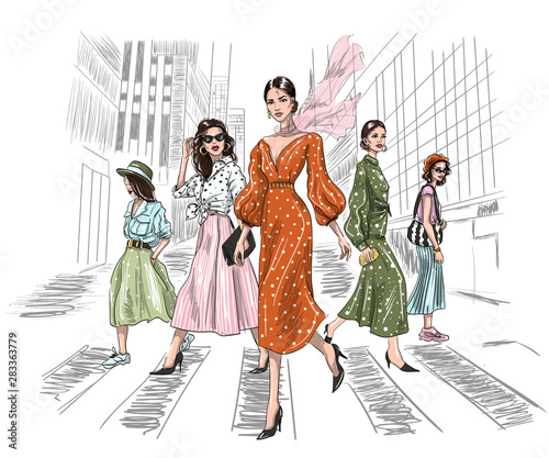 five women walking on a crosswalk in big city