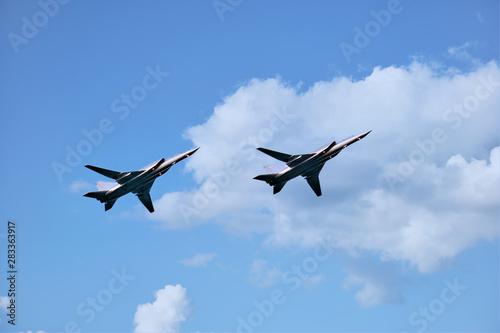 Two aircrafts against summer clear sky and clouds