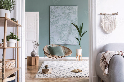 Boho interior design with rattan armchair and bamboo shelf