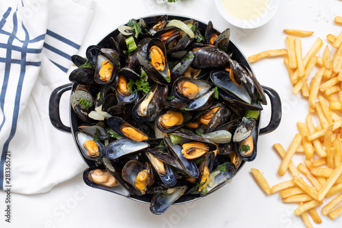 Belgian mussels with potato fries on white marble table flat lay view 