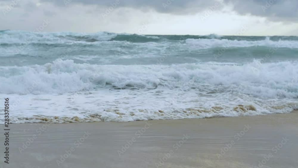 Slow motion of sea water with big surf wave splashing the beach under rain clouds sky at karon beach, Phuket, Thailand. Slow motion of sea water with big surf wave splashing the beach under rain clouds sky at karon beach, Phuket, Thailand.