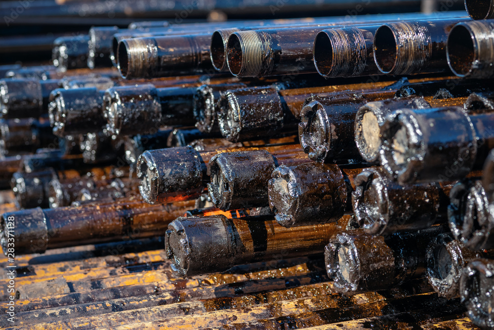 Oil Drill pipe. Rusty drill pipes were drilled in the well section. Downhole drilling rig. Laying the pipe on the deck. View of the shell of drill pipes laid in courtyard of the oil and gas warehouse