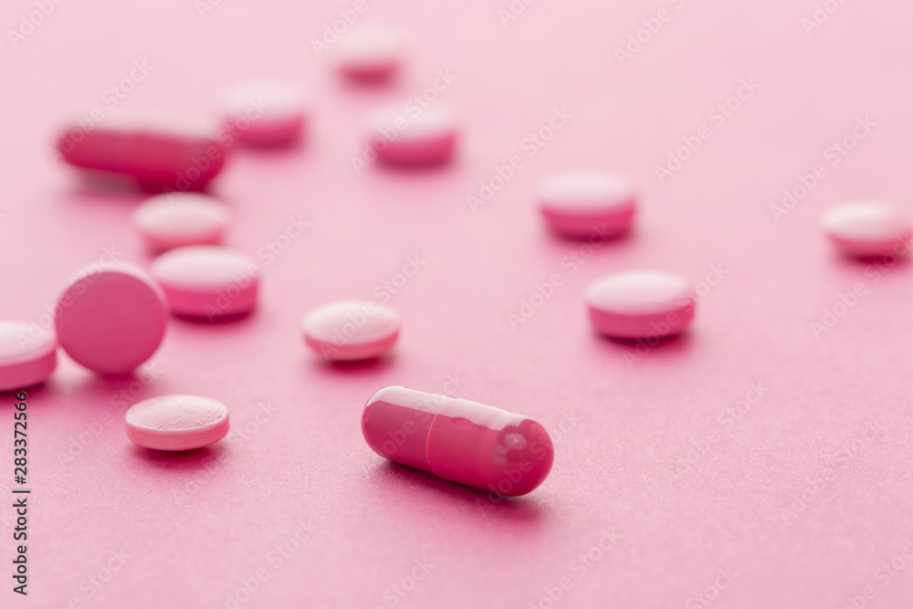 Various red colour medication capsules. Red background