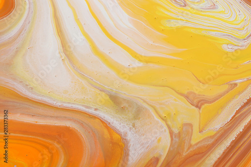 photography of abstract marbleized effect background. orange, gold, yellow and white creative colors. Beautiful paint.