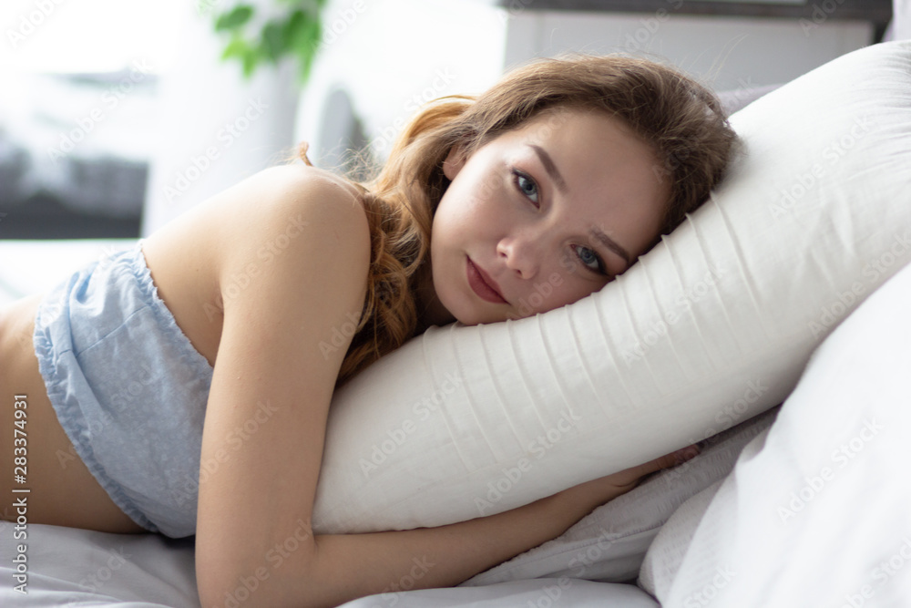 Young woman lying on pillow in the bedroom Young woman lying on pillow in the bedroom