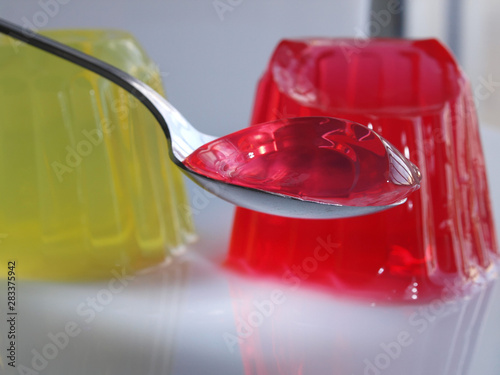 Billede på lærred spoon full of sweet jelly pudding strawberry flavor over white background