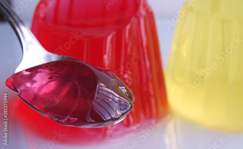 spoon full of sweet jelly pudding strawberry flavor over white background