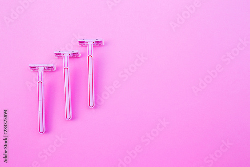 Three women s razors pink color on an isolated pink background.