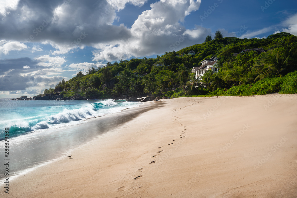 Exotic tropical beach Anse Takamaka on Seychelles islands, Mahe. Scenic view with impressive clouds on sunny day