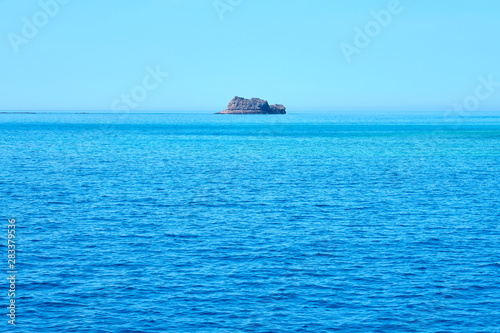 Rocky island in the middle of the sea. Natural background texture. Copy space. © Arthur