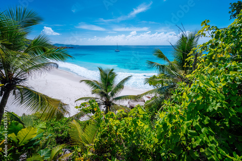 Amazing wild tropical beach Petite Anse with lush vegetation on La Digue Island  Seychelles