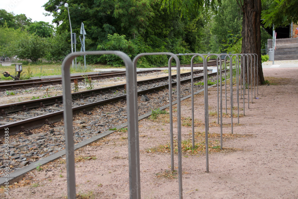 Bicycle stands with railway tracks in background
