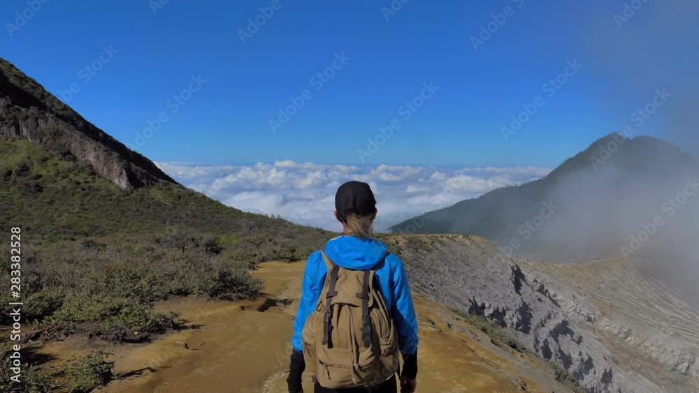 Tourist walking on the mountain valley area above the clouds, volcano Ijen area in Java island, Indonesia Tourist walking on the mountain valley area above the clouds, volcano Ijen area in Java island, Indonesia