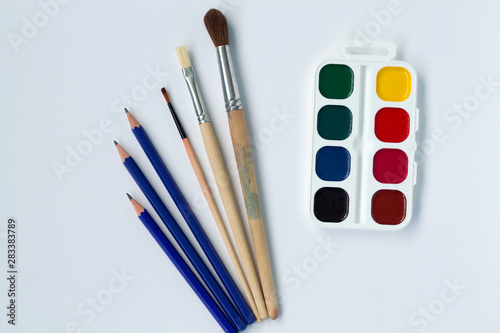 paints and brushes isolated on white background top view