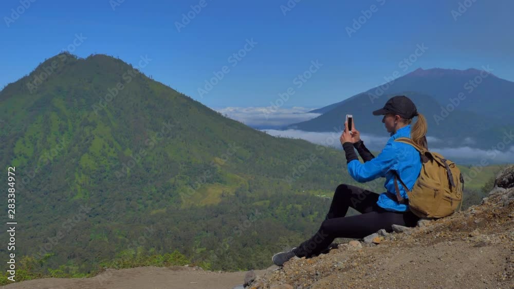 the traveler takes a mobile photo in the valley of ijen volcano in Java island, Indonesia the traveler takes a mobile photo in the valley of ijen volcano in Java island, Indonesia
