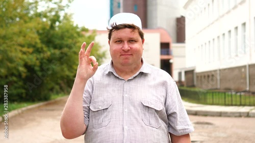 Young muslim man in city giving ok sign