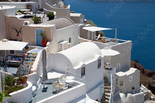 White houses and characteristic blue sea landscape at Santorini island in Greece. Typical urban agglomeration with the houses wedged together.