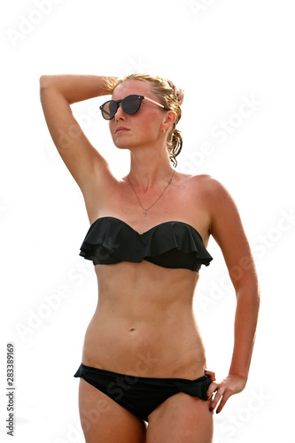 Woman in sunglasses and black swimsuit on white background © sunselle