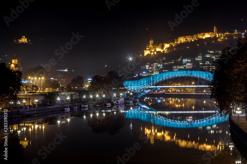 Pedestrian bridge of peace over the Mtkvari (Kura) River in Tbilisi at night. Narikala fortress.