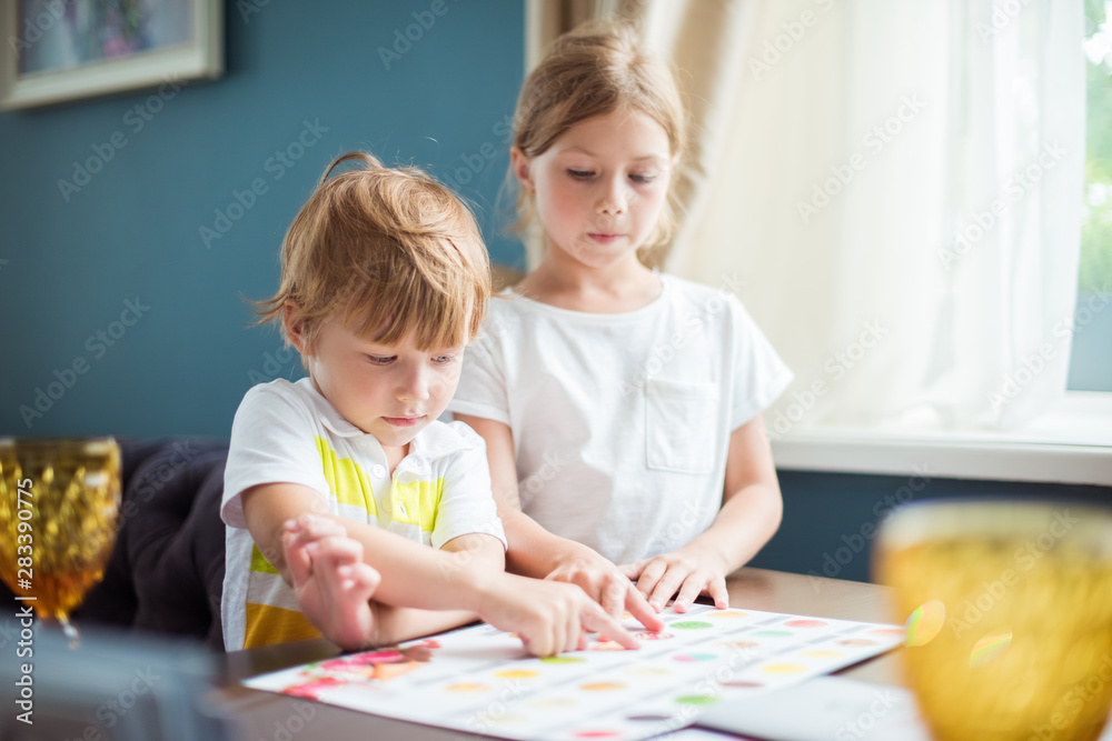 Cute little children choosing their meal in a kid's menu in a restaurant Cute little children choosing their meal in a kid's menu in a restaurant
