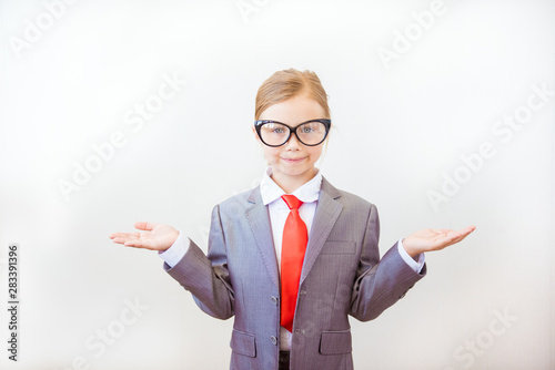 Smiling child girl pointing his index finger at something on white background. Success, creative and innovation business concept