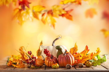 Autumn background from fallen leaves and pumpkins on wooden vintage table. Autumn concept with red-yellow leaves background. Thanksgiving pumpkins.