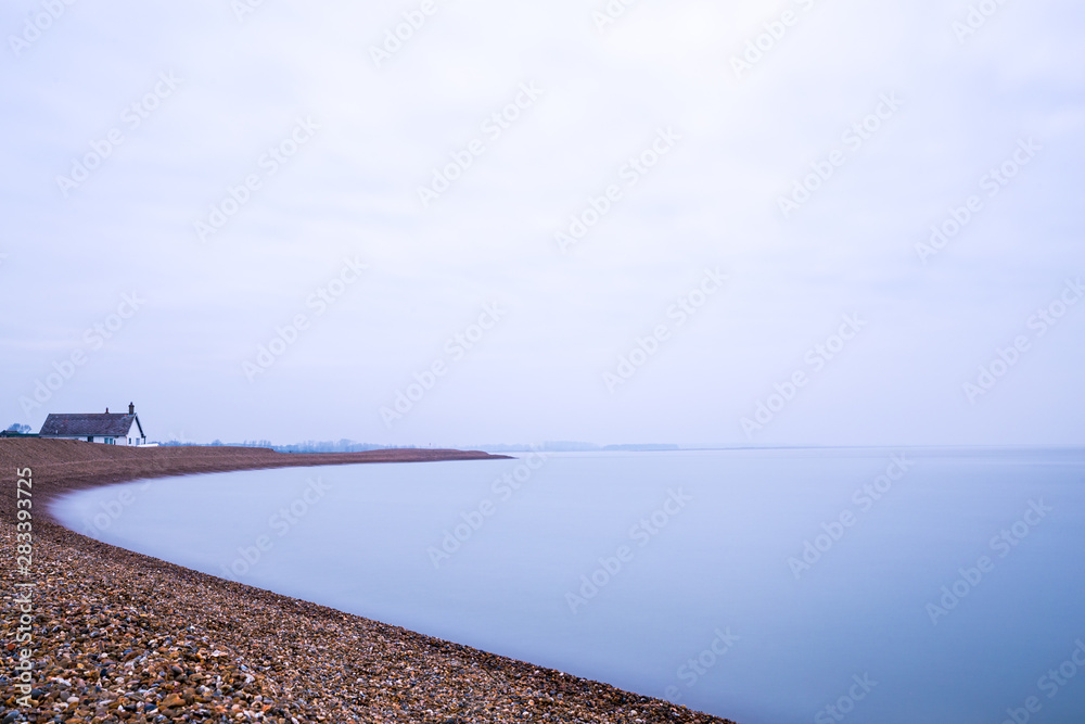 A long exposure of the clouds and water at Shingle Street in Suffolk. The water has taken on a milky effect and there is lots of negative space