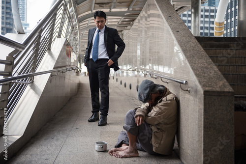Принти на полотні Mercy Businessman look at Homeless in city
