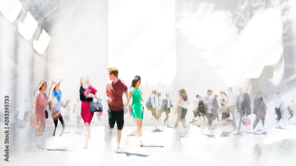 Fototapeta premium Lots of walking people in big exhibition place. Beautiful people blur image with space for text