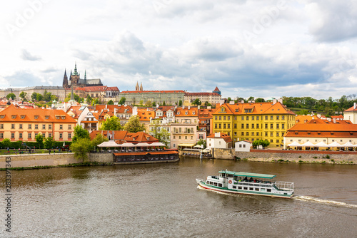 Prague cityscape with pleasure boat on river