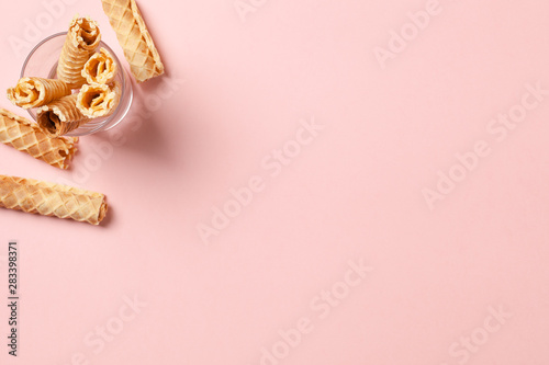 Wafer rolls with a sweet sauce. On a multicolored background. Minimalism