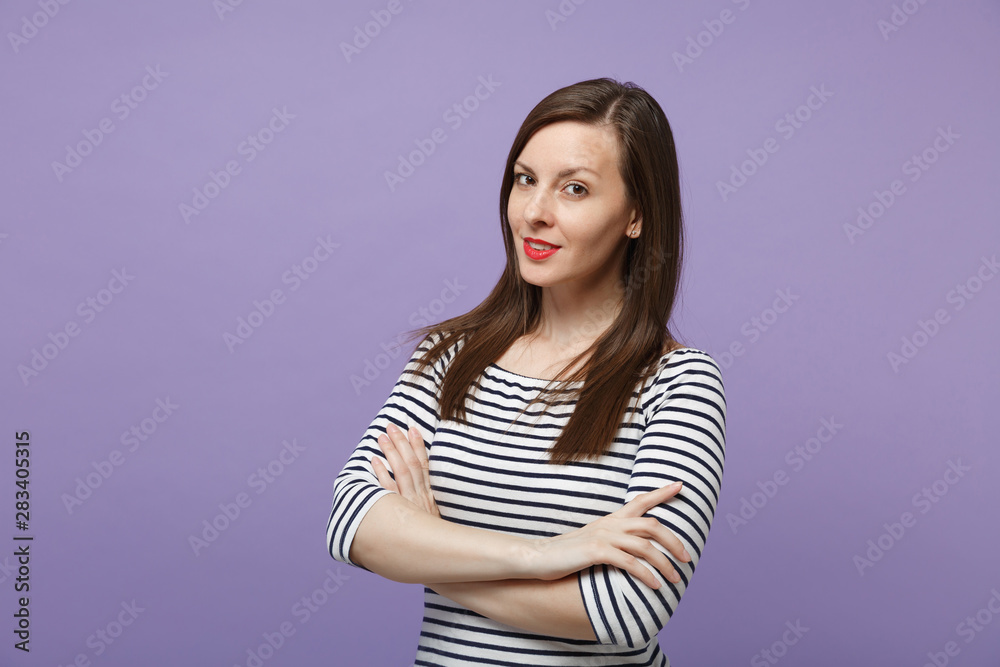 Beautiful young woman girl in casual striped clothes posing isolated on violet purple background studio portrait. People lifestyle concept. Mock up copy space. Looking camera, holding hands crossed. Beautiful young woman girl in casual striped clothes posing isolated on violet purple background studio portrait. People lifestyle concept. Mock up copy space. Looking camera, holding hands crossed.