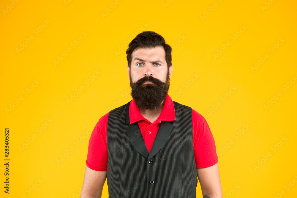 Fototapeta premium Shop staff concept. Salesman cashier career. Hiring shop store worker. Hospitality staff. Restaurant cafe staff wanted. Man bearded hipster with mustache wear vest and shirt uniform yellow background