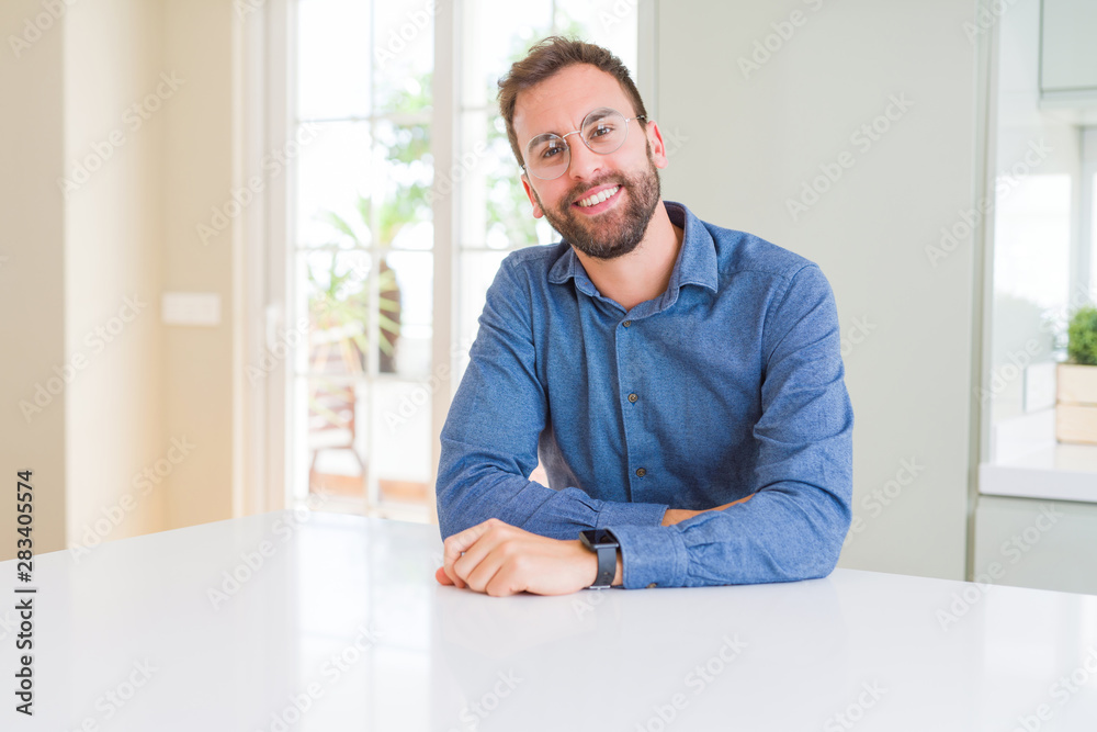 Handsome man wearing glasses and smiling relaxed at camera