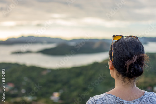 Dark haired woman taking in an elevated view of the sea and islands around Coron, Palawan Philippines.
