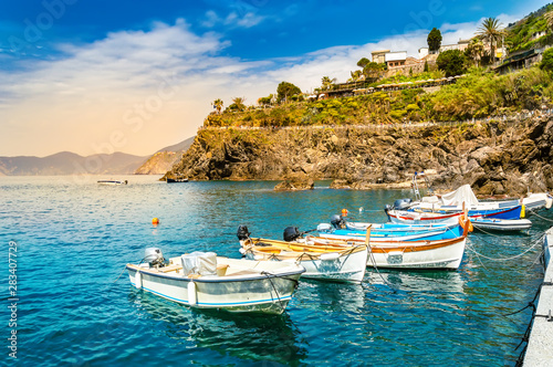 Manarola, Cinque Terre - fishing boats in a sea near romantic village on cliff in Cinque Terre National Park