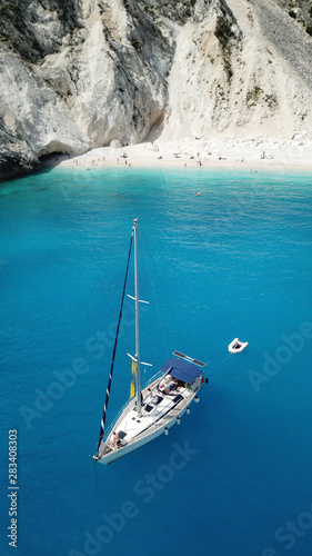 Aerial top view photo of sun beds and umbrellas in popular tropical paradise deep turquoise Mediterranean sandy crowded beach