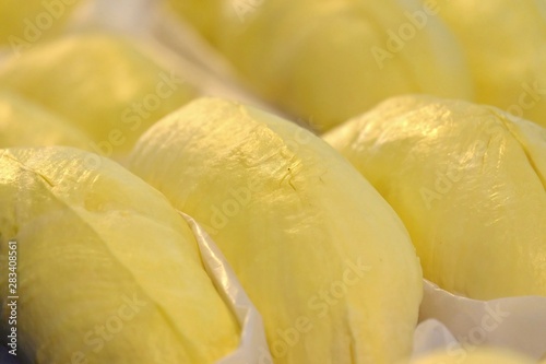 Close up yellow pulp of a Thai tropical Durian fruit with seeds and selling at the wholefood market in indoor place