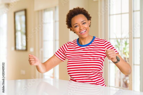 Young beautiful african american woman at home Dancing happy and cheerful  smiling moving casual and confident listening to music